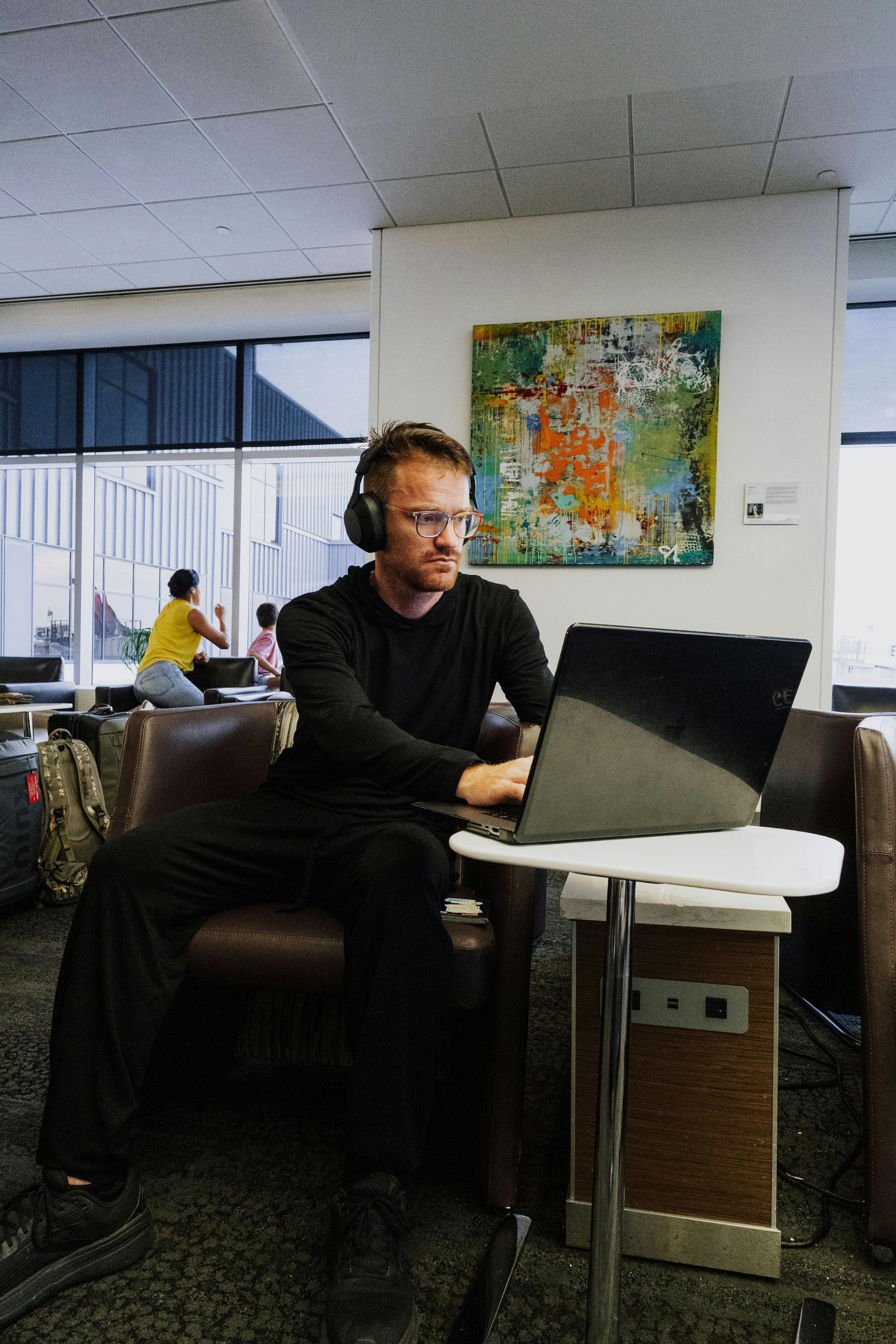 professional using laptop in airport lounge representing remote work and global connectivity
