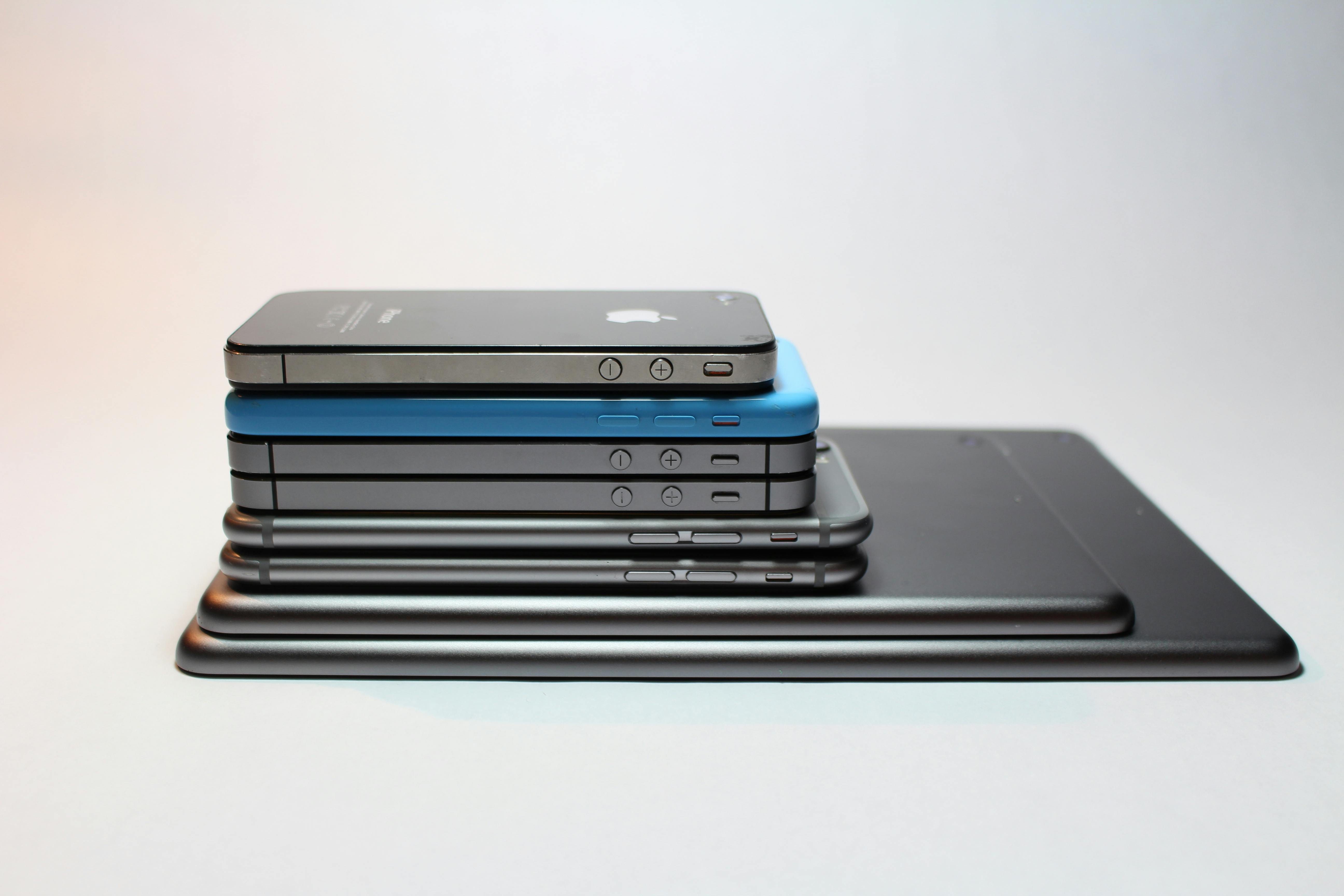 a stack of iPhones and iPads by model year