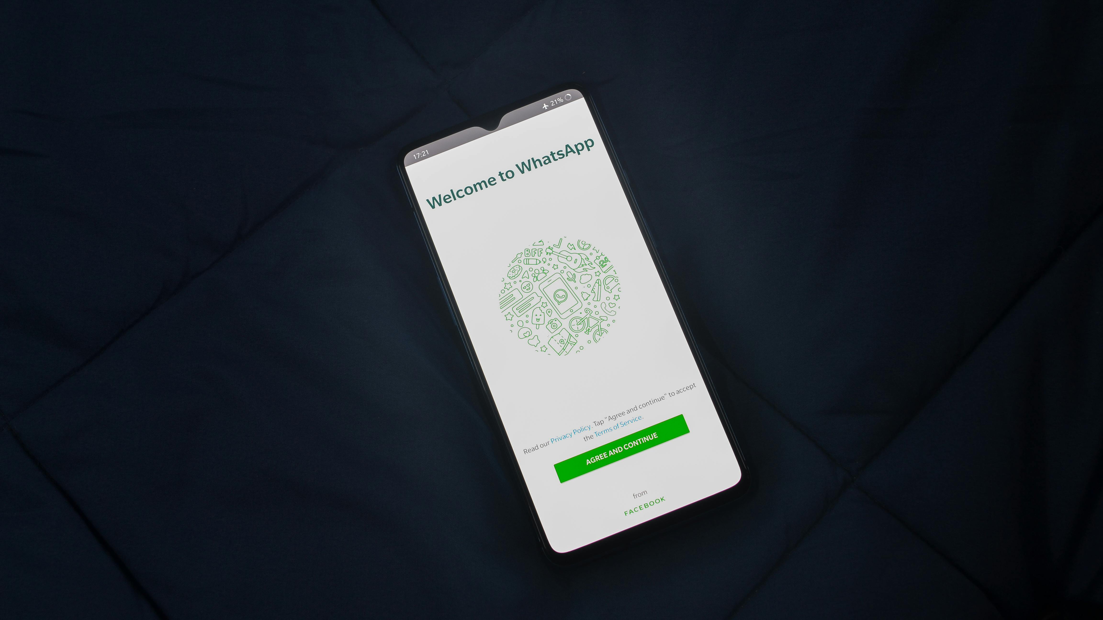 mobile phone showing image of the WhatsApp welcome page