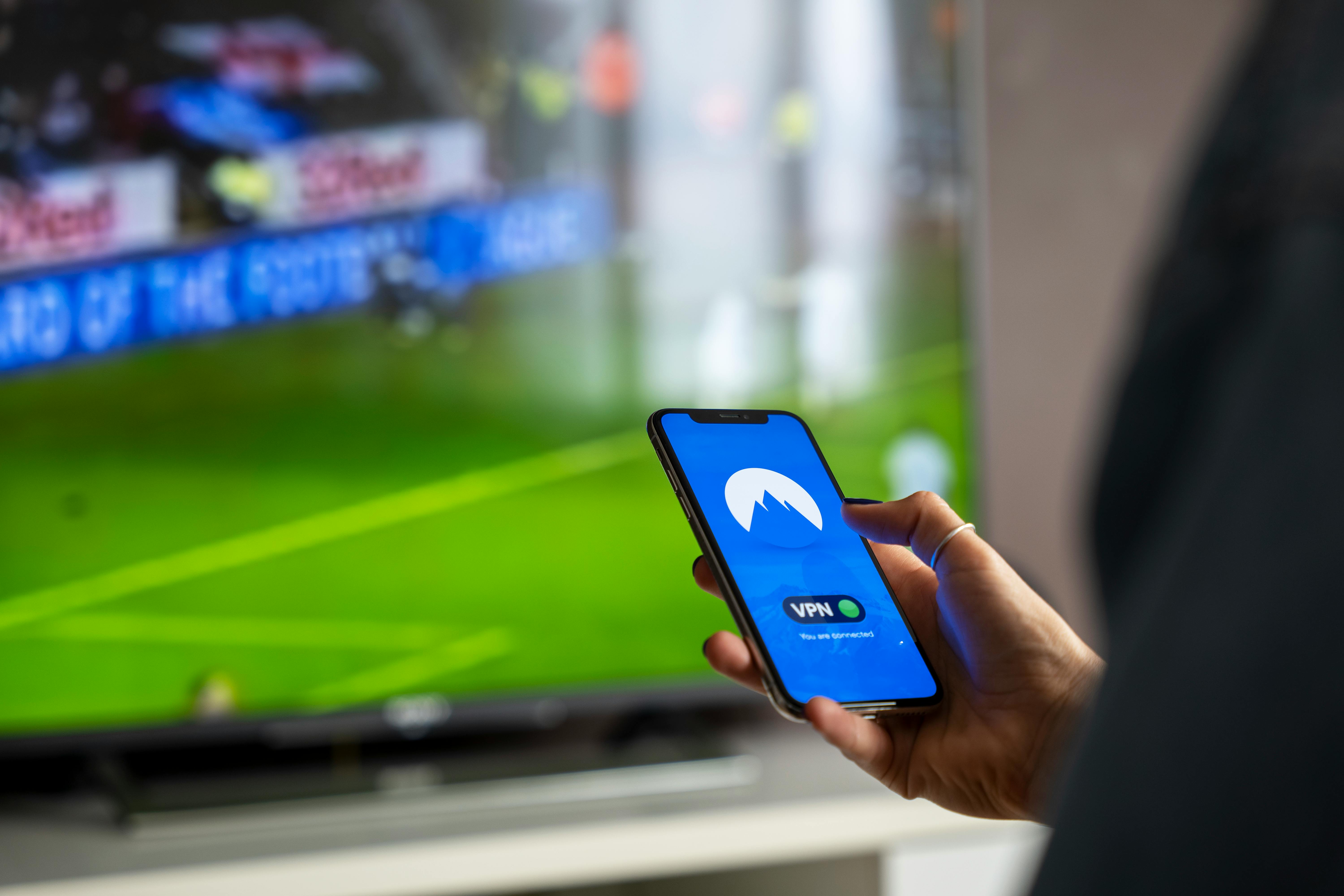 person on mobile phone at a soccer (football) match