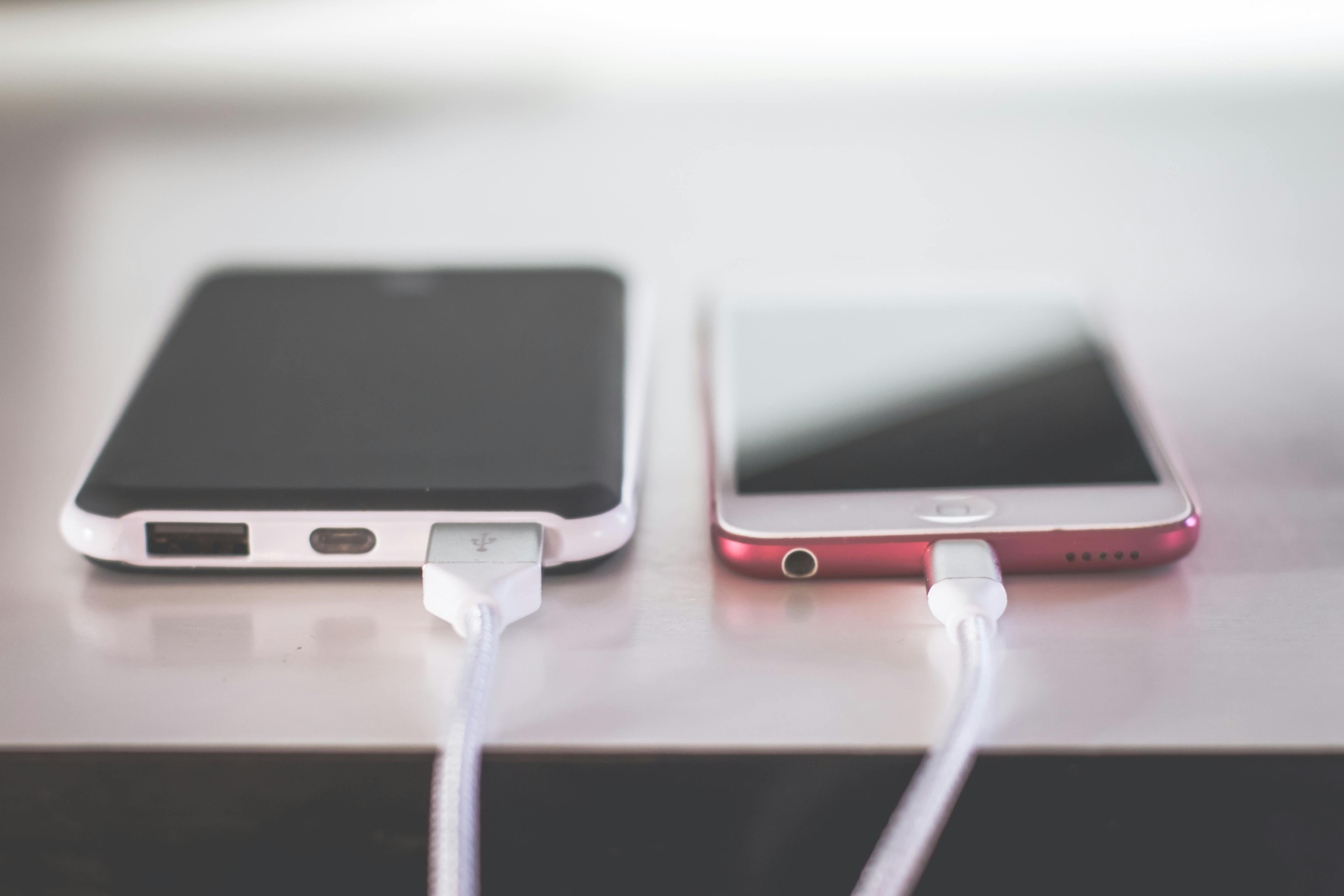 two smart phones on desk, charging